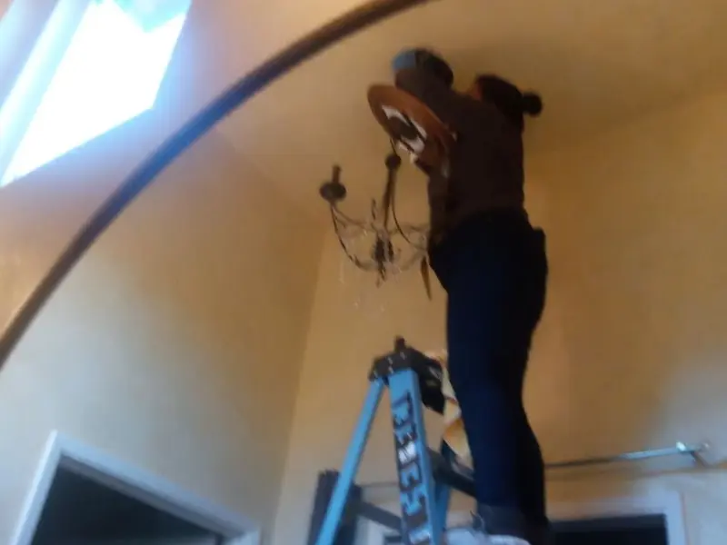 Electrician installing a chandelier in a Dunstable residence